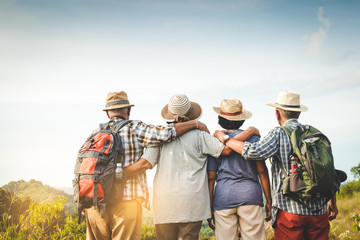 A group of Asian seniors hiking and standing on high mountains enjoying nature. Senior community...
