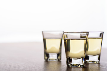 Vodka in a shot glass on a brown wooden background prepared for a party