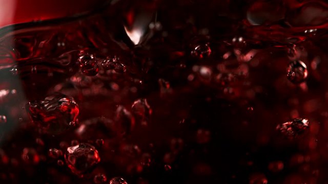 Super slow motion of pouring red wine in macro shot. Filmed on high speed cinema camera, 1000 fps