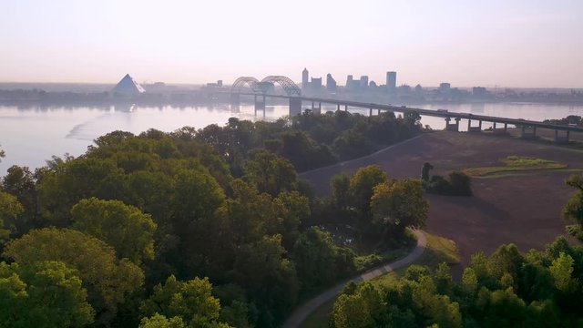 Good early morning aerial skyline and business district Memphis Tennessee across the Mississippi River with Hernando de Soto Bridge foreground.