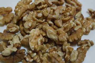 Close-up top view of peeled walnut on a white background