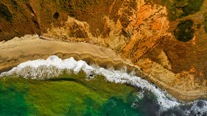 Aerial shot of a beach and waves at sunset 