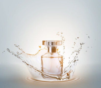 Bottle of perfume with splash on light background