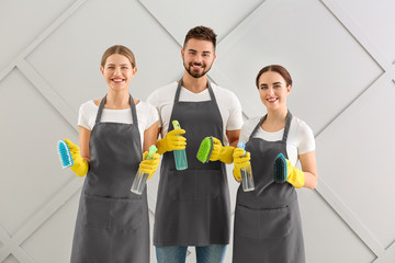 Team of janitors on grey background