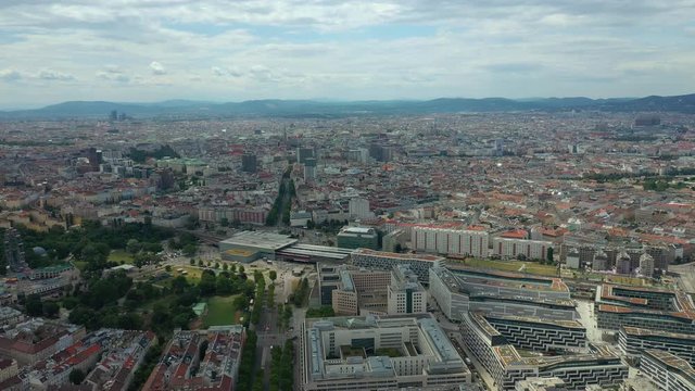 flight over vienna city sunny day traffic street train station district aerial panorama 4k austria