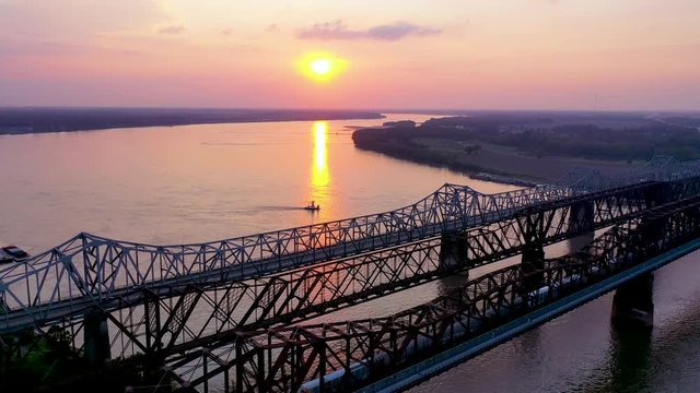 Aerial of landmark three steel bridges over the Mississippi River at sunset with Memphis, Tennessee background.