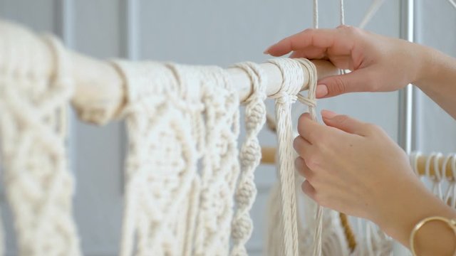 close-up female hands of a master throws a rope on macram