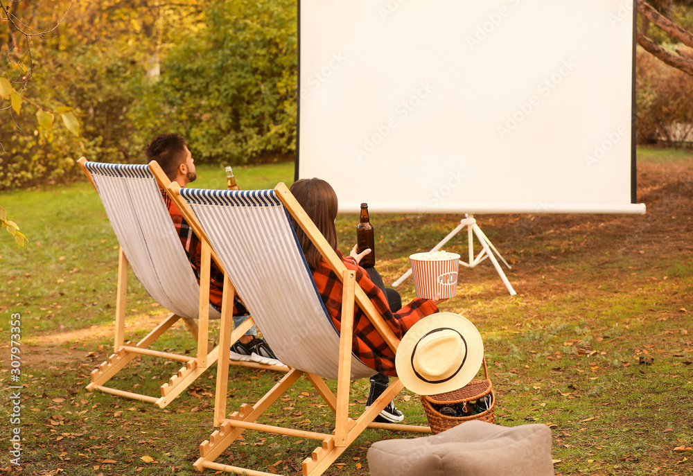 Poster Young couple watching movie in outdoor cinema