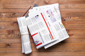 Many newspapers on wooden background