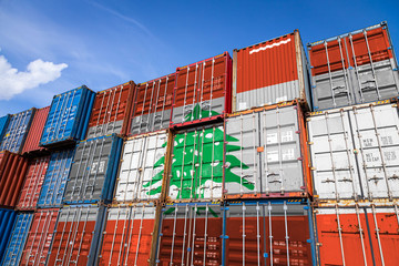 The national flag of Lebanon on a large number of metal containers for storing goods stacked in rows on top of each other. Conception of storage of goods by importers, exporters