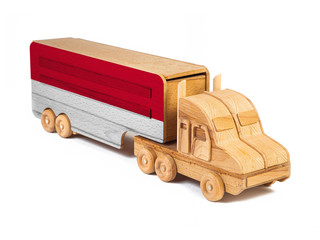 Close-up of a wooden toy truck with a painted national flag Indonesia. The concept of export-import,transportation, national delivery of goods