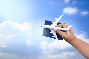 Concept: a boy holding a plane, a white toy with a passport Moving in the bright sky. with copy space.