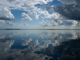 Sky art image. White Cumulonimbus cloud in blue sky with ocean water reflections. Australia.