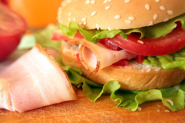 Delicious hamburger sandwich with meat, cheese and fresh vegetables.  or a sandwich for breakfast or lunch.  Juicy Cheeseburger