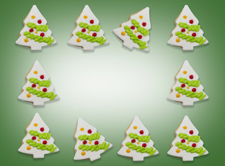 Glazed cookies in form of Christmas tree decorated with colorful frosting on green gradient background. with copy space at centerpoint