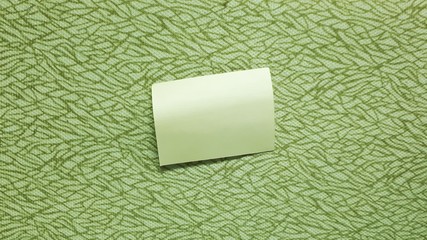 Blank sticky note paper on green wall / bakcground.