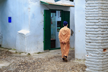 Unknown man in national clothes on the old street in Tetouan Medina quarter in Northern Morocco. A...