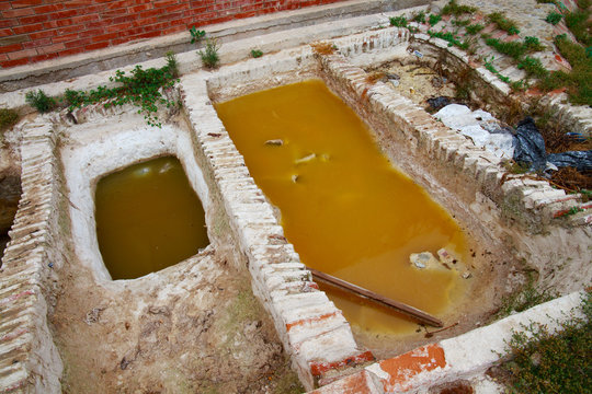 Different old stone vats with dye for leather at Tannery of Tetouan Medina. Northern Morocco.