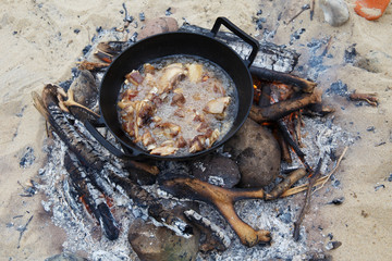 Pieces of lamb are fried in boiling oil in a pan on the fire. As a stage in the preparation of traditional pilaf.