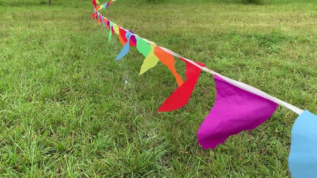 Colorful triangle flags on the string waving in the wind on a soccer field during sport festival