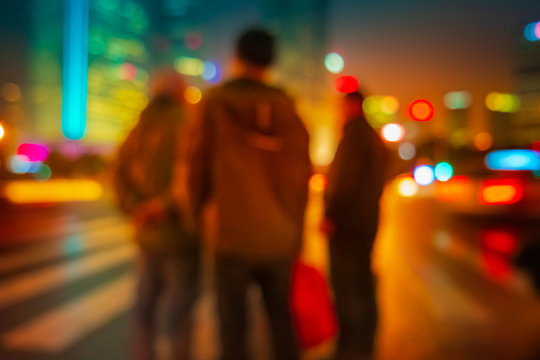 Abstract background of People across the crosswalk at night in Shanghai, China.