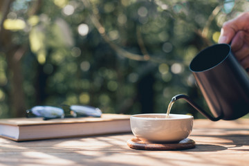 Garden reading table, Pouring tea into the teacup, Close-up