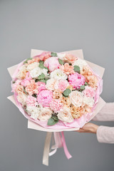 Pink peonies, Sarah Bernhardt and different flowers. European floral shop. Beautiful bouquet in womans hands. the work of the florist at a flower shop. Delivery fresh cut flower.