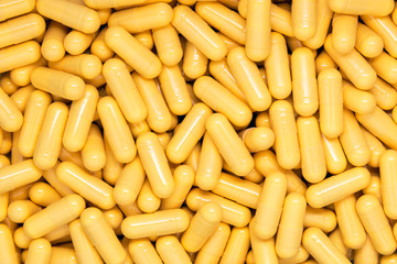Yellow drug capsules background. Medical concept for your design.