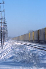 A freight train recedes into the distance on a snowy winter day. 