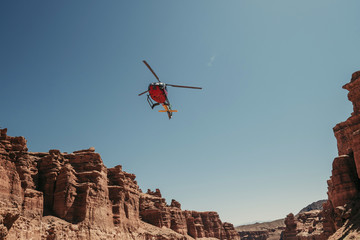 Fototapeta na wymiar Helicopter flying above red cliffs canyon landscape. Charyn in Kazakhstan, small copy of Grand canyon in US