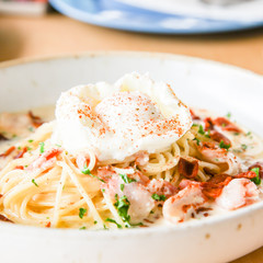 Pasta cream sauce with bacon and poached egg