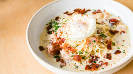 Pasta cream sauce with bacon and poached egg