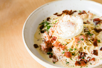 Pasta cream sauce with bacon and poached egg
