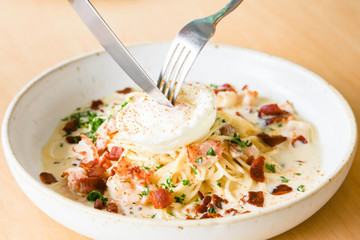 Pasta cream sauce with bacon and poached egg