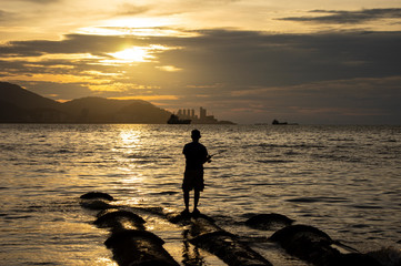 silhouette of fisherman at sunset