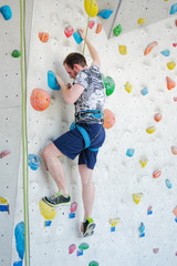 Fototapeta premium A man climbs up on a climbing wall.