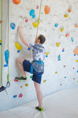 Fototapeta premium A man climbs up on a climbing wall.