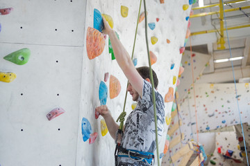 Fototapeta premium A man climbs up on a climbing wall.