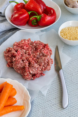 Preparing  stuffed red peppers with minced meat, rice and vegetables