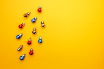 Christmas composition. Christmas colored balls on christmas tree shape on yellow background. Flat lay.