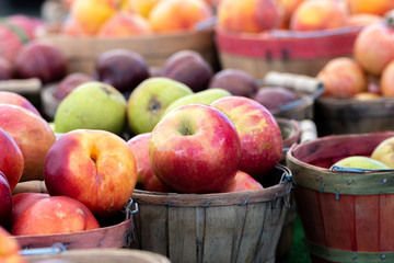 Batches of apples in wooden baskets for sale at a local farmers market