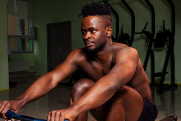 Fototapeta na wymiar Male athletewith dreadlocks working out in the gym