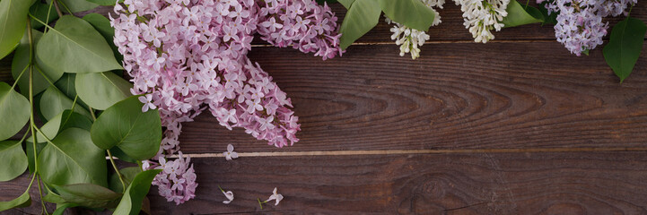 Decor of flowers on the background of vintage wooden planks.Vintage background with lilac flowers and place under the text. View from above. Flat lay. Banner.