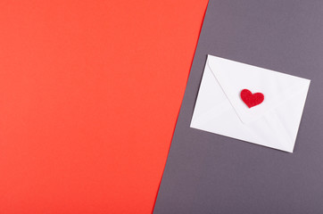 Obraz premium Paper envelope with red heart composition on red background.