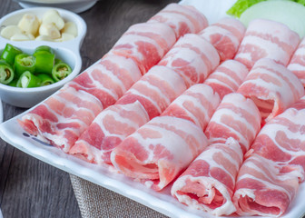 Set of raw fresh pork slide in white plate serve with many kind of vegetable.