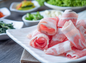 Set of raw fresh pork slide in white plate serve with many kind of vegetable.