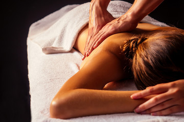 Fototapeta premium close-up masseur hands doing back massage to female client in spa center