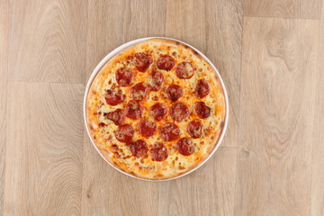 Pepperoni pizza with vegetables on a wooden background - salami