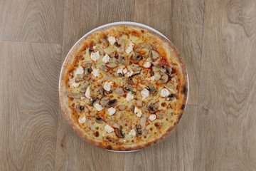 chicken pizza with vegetables and cheese on a wooden background