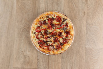 Pepperoni pizza with vegetables on a wooden background - salami